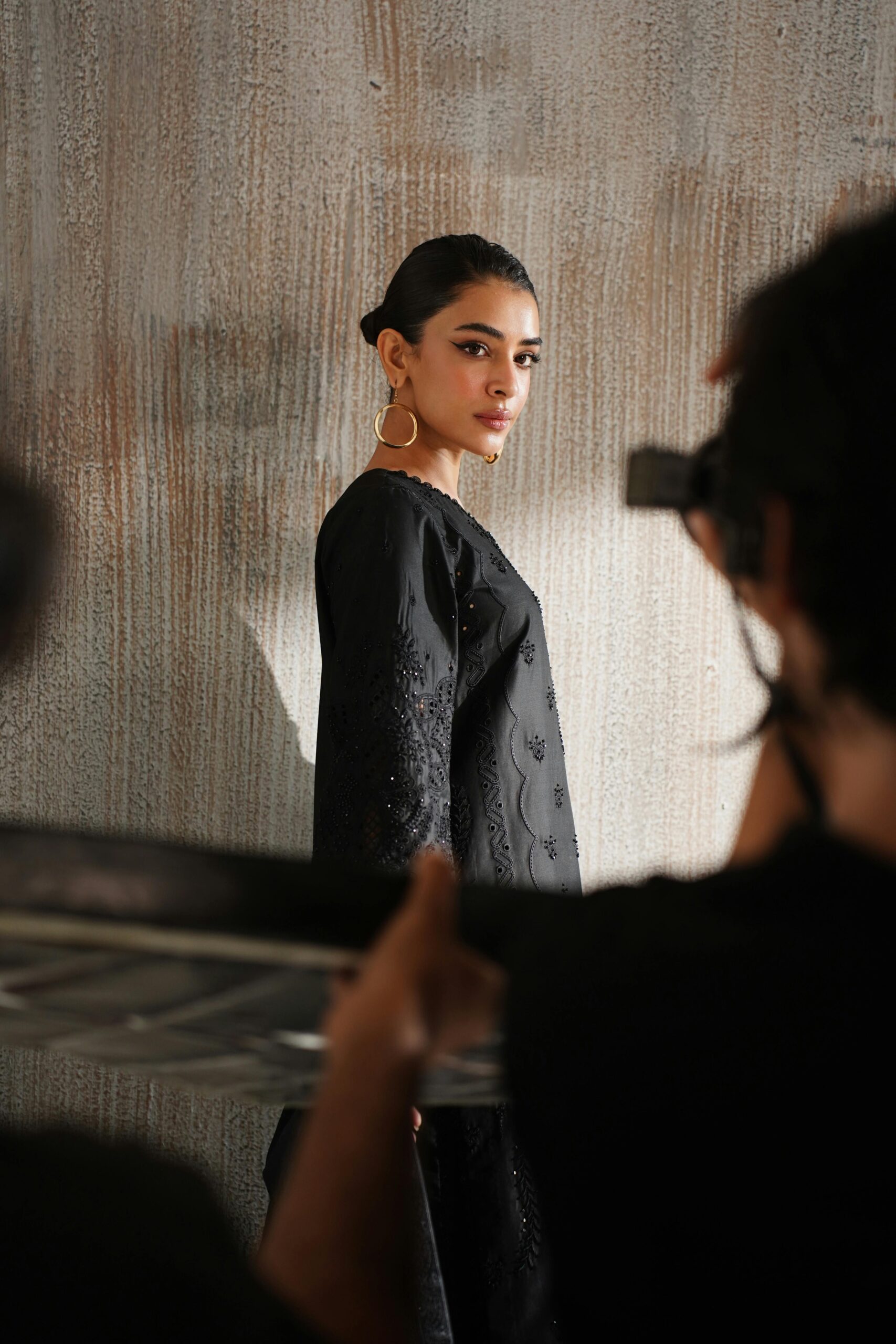 Elegant portrait of a model in a black dress captured in a Lahore studio setting, showcasing contemporary fashion.